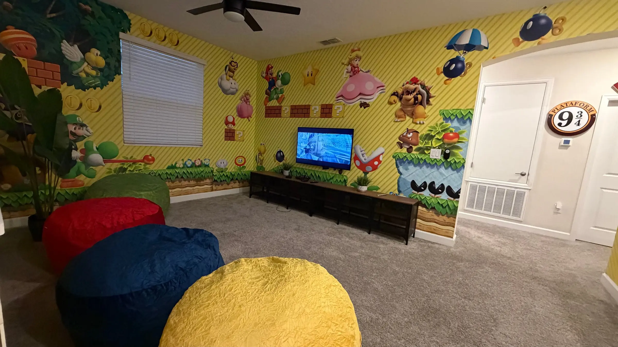 Game room with themed printed wallpaper, bean bags and a wall-mounted TV