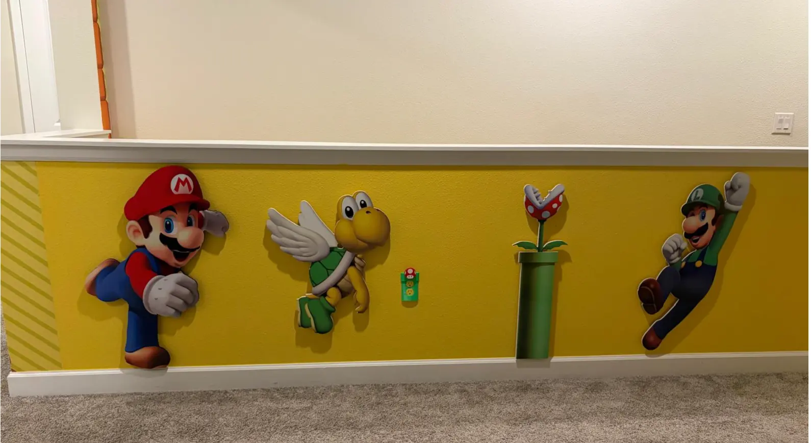 Yellow printed wall band with character cutouts along a hallway