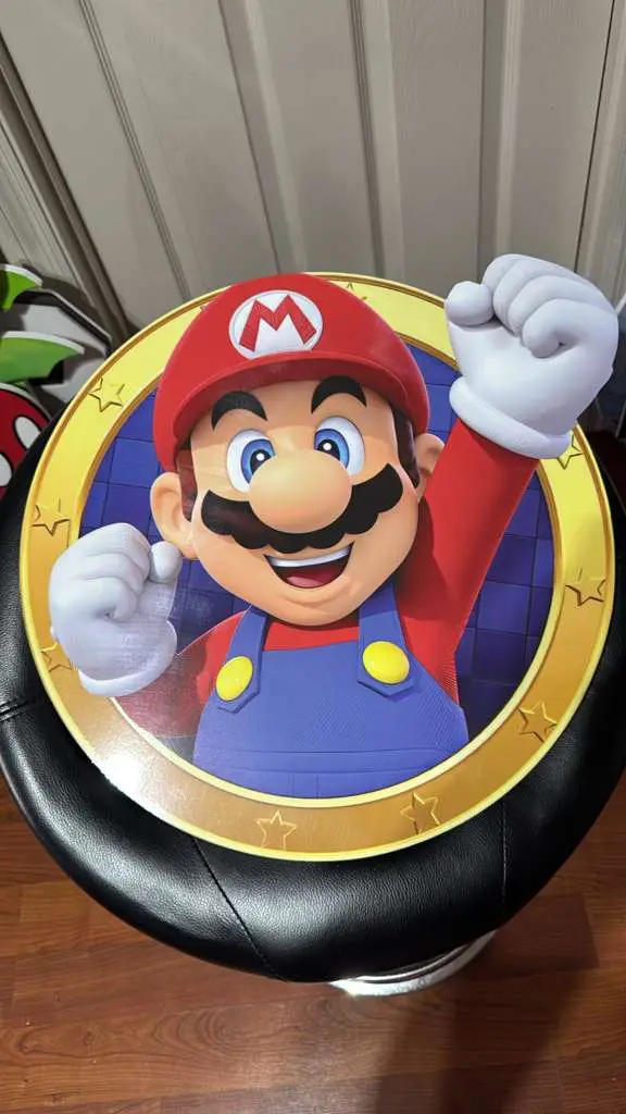 Round printed character medallion with a gold rim on top of a black stool